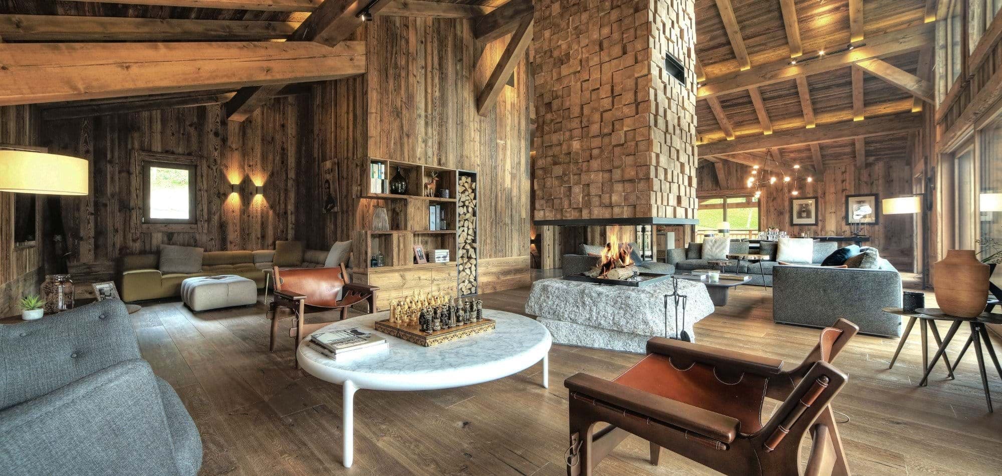 Living area featuring central 360-degree wood-burning fireplace and vaulted timber ceilings