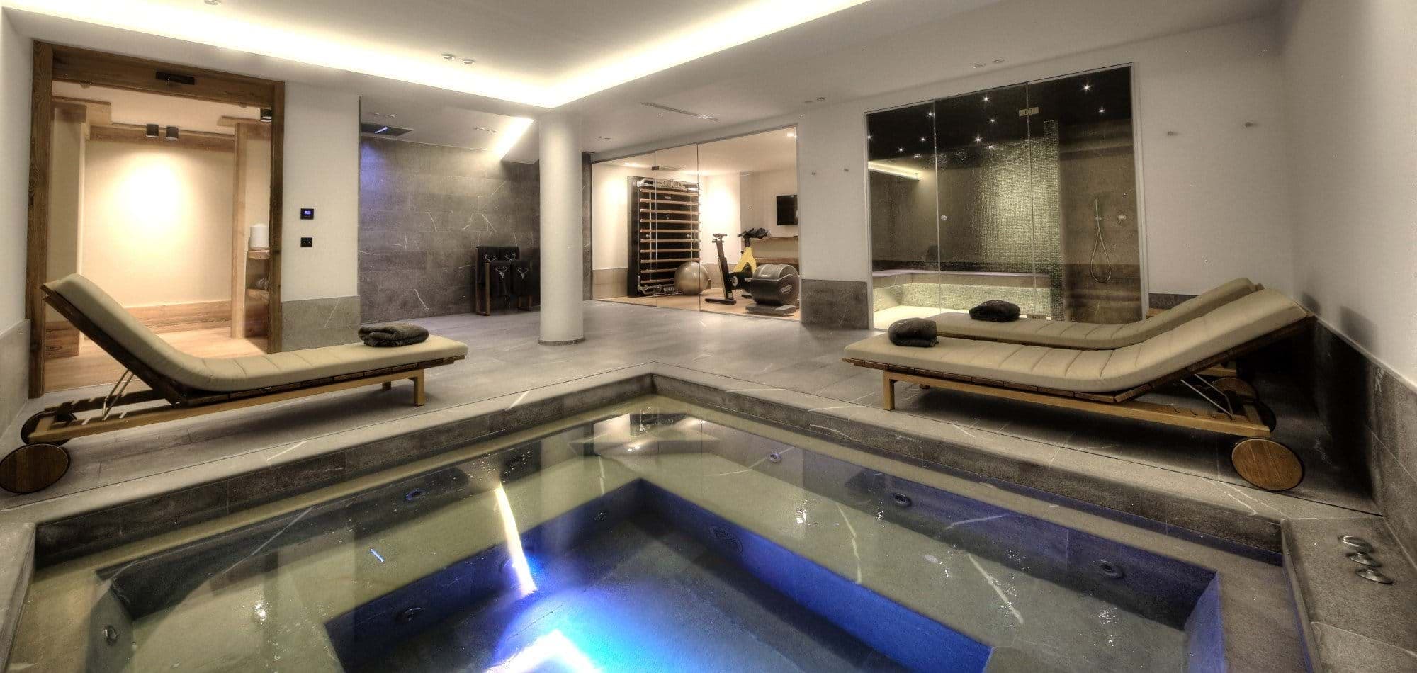 Indoor spa with hot tub, steam room, and adjacent fitness suite