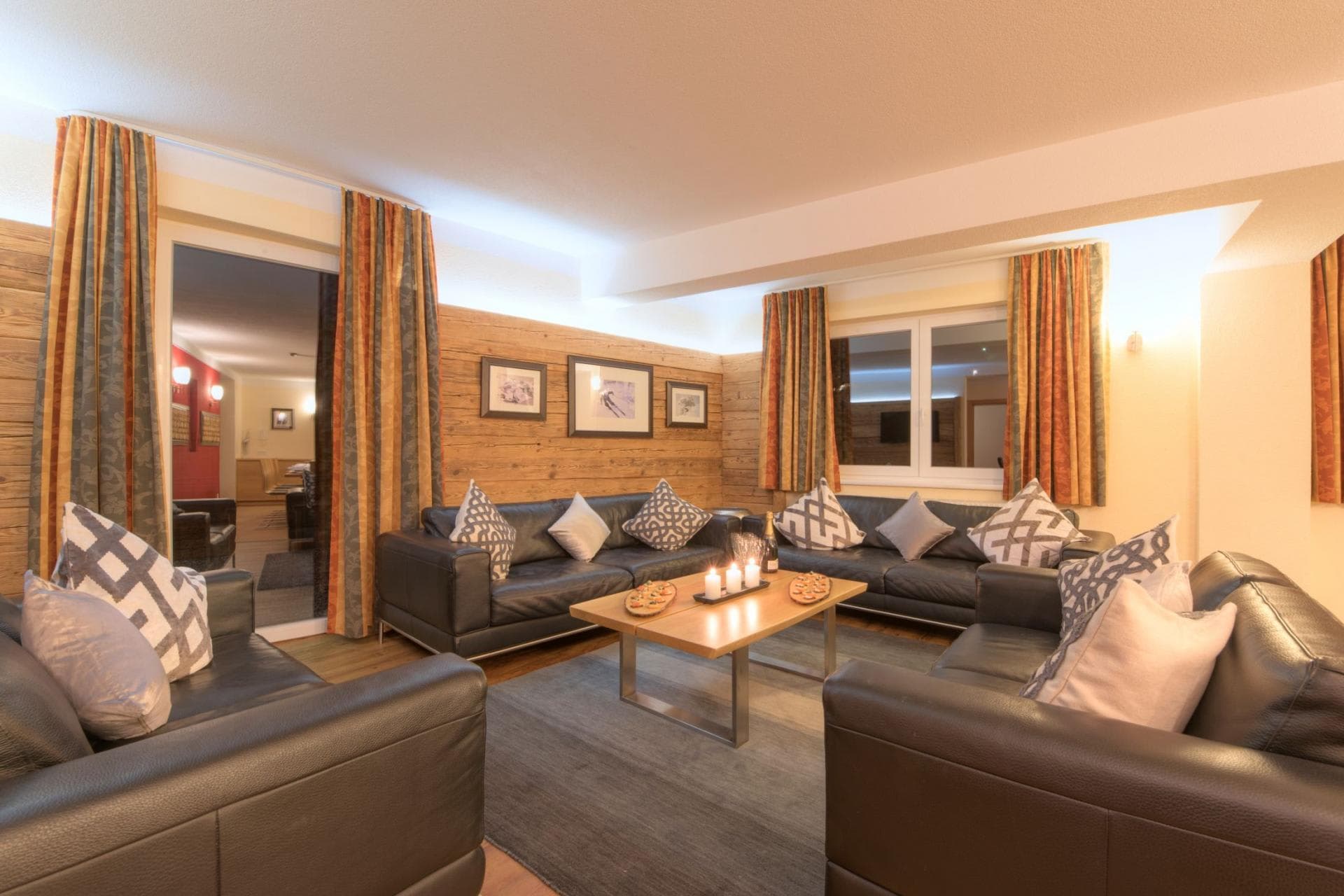 Living area with leather sofas, wood paneling, and seating for 10