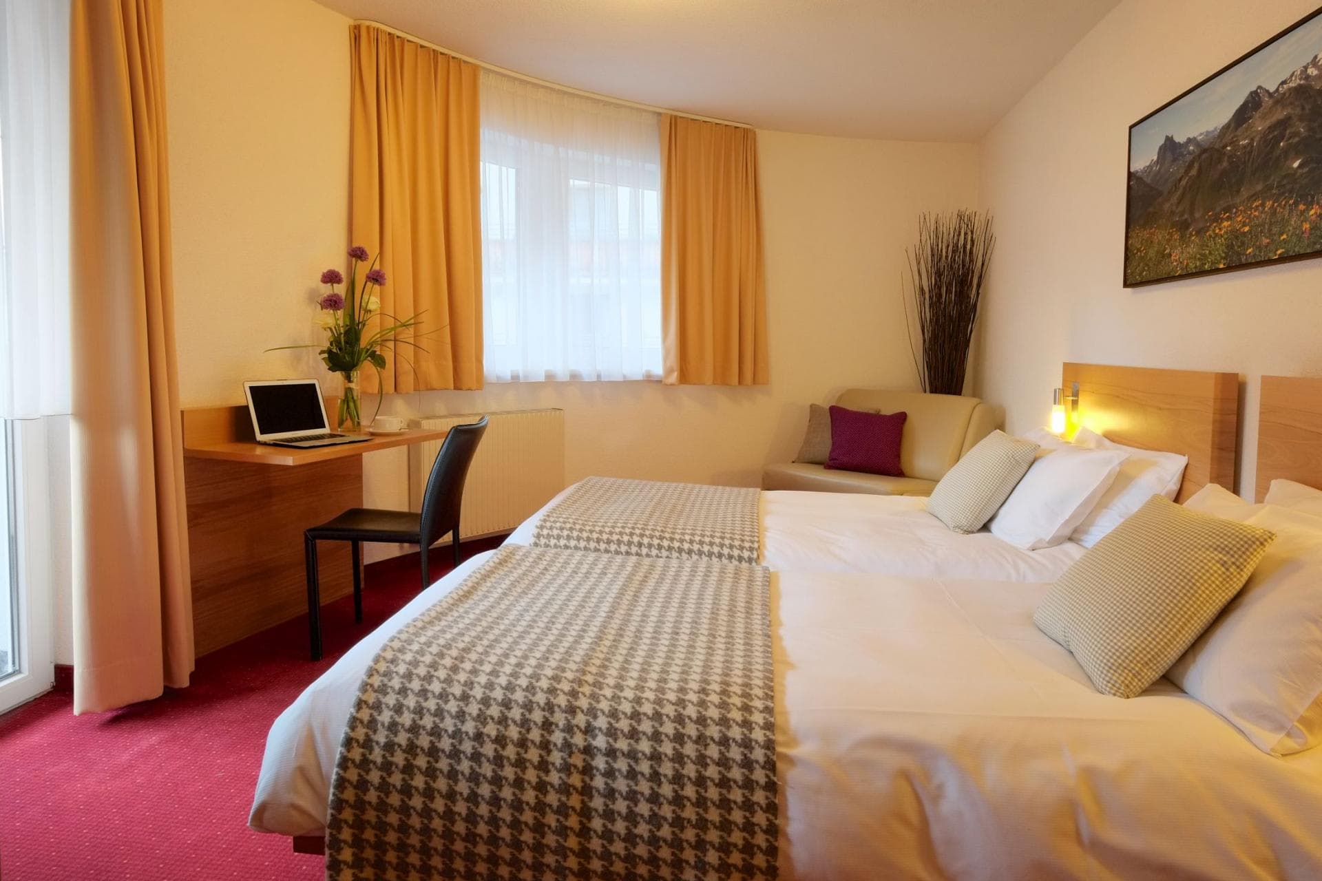 Guest bedroom with two twin beds and dedicated laptop workspace