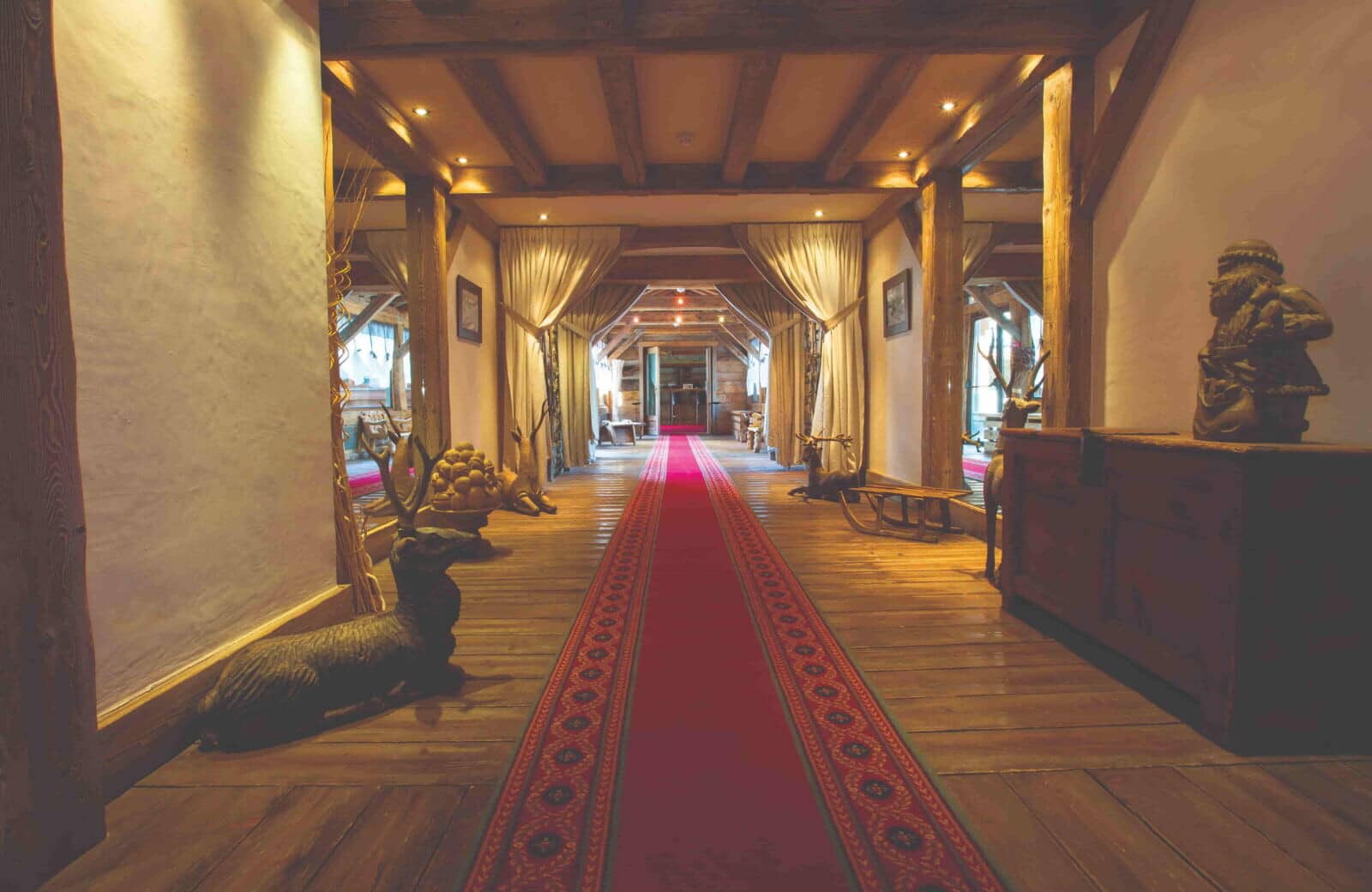 Grand hallway with timber beams, original wood floors, and recessed lighting
