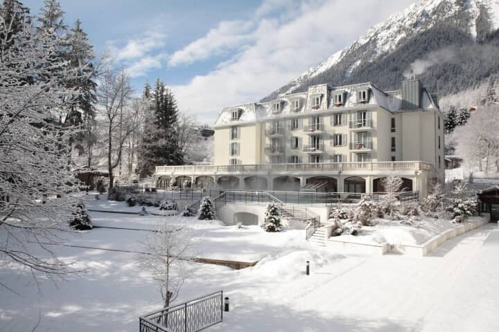 Hotel exterior featuring heated outdoor pool with mountain views