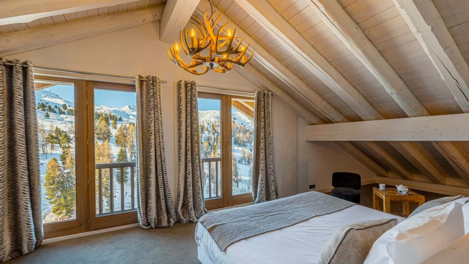 Top-floor bedroom with vaulted ceilings and mountain views via Juliette balconies