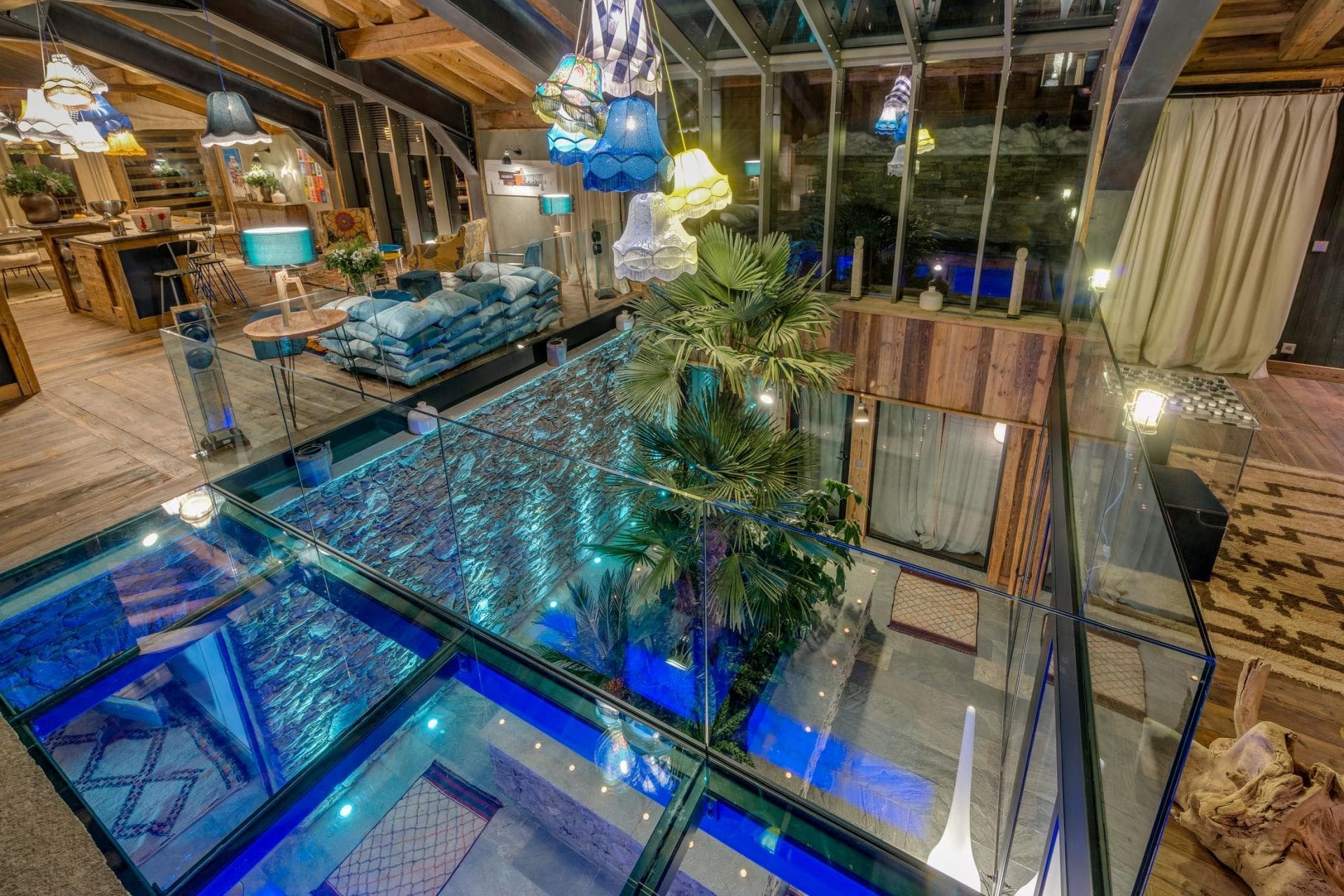 Living area with glass floor overlooking lower-level indoor pool