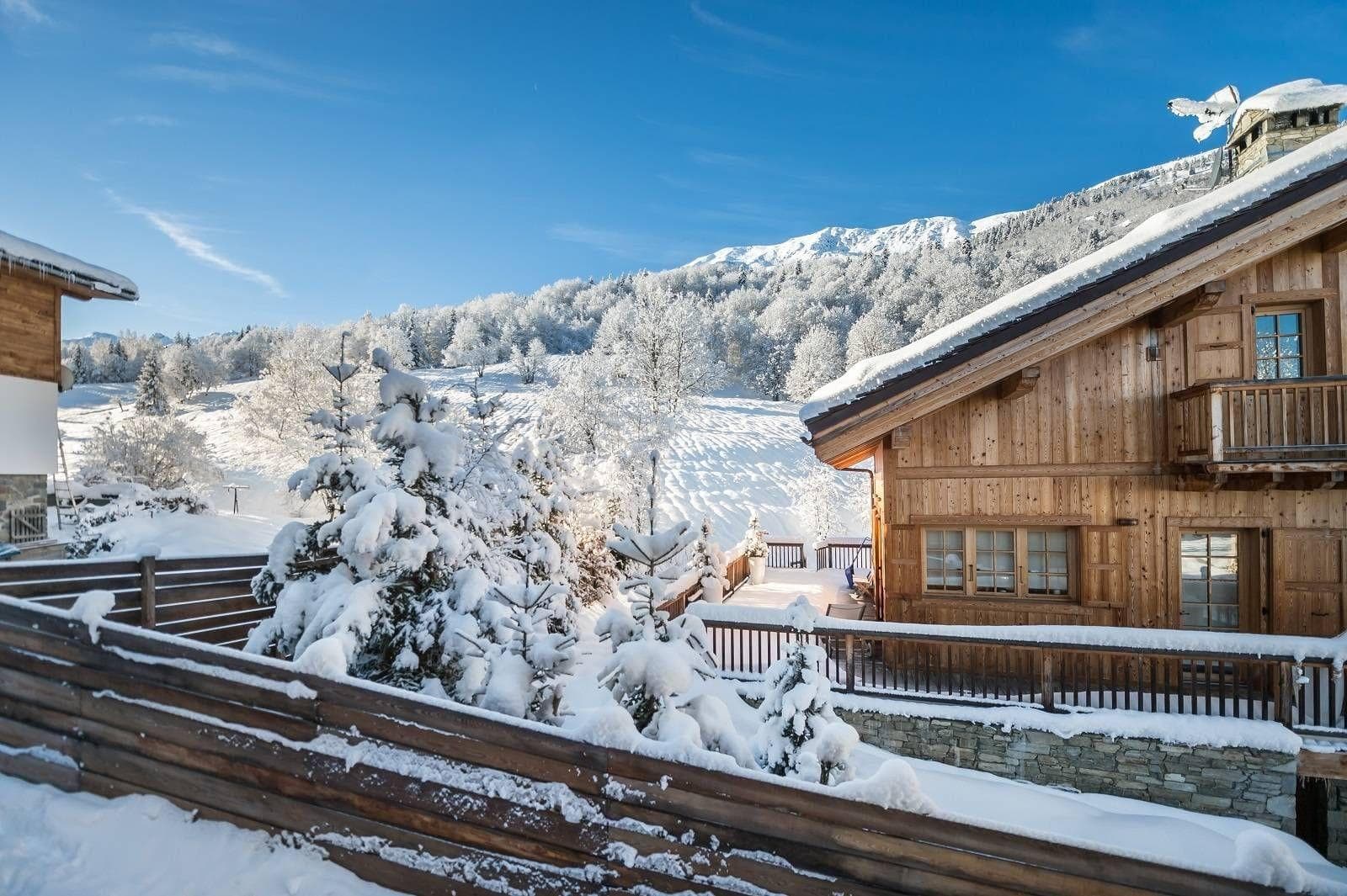 Chalet exterior with timber facade and snowy mountain views