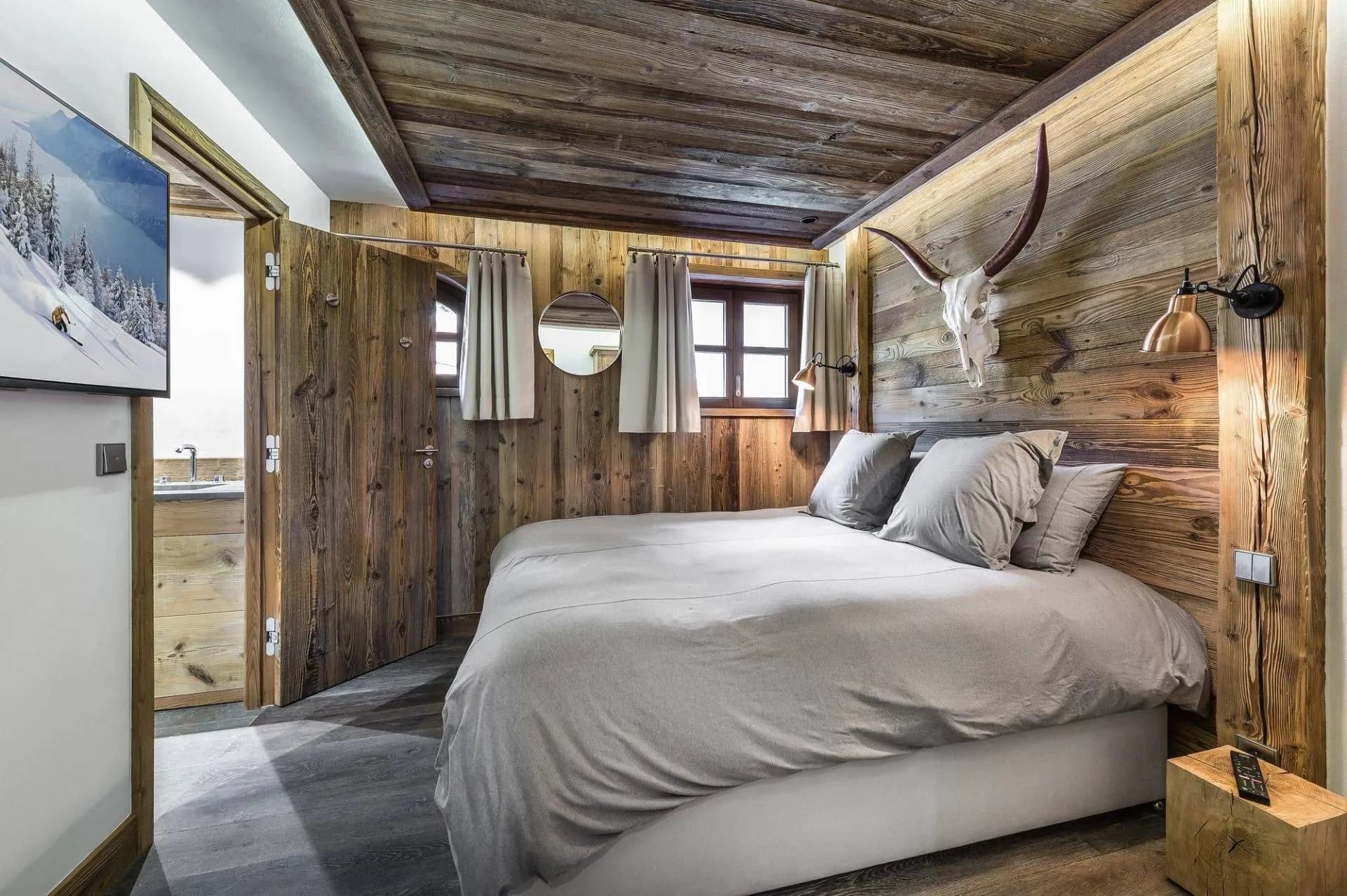 Double or twin bedroom with timber walls and an en-suite doorway