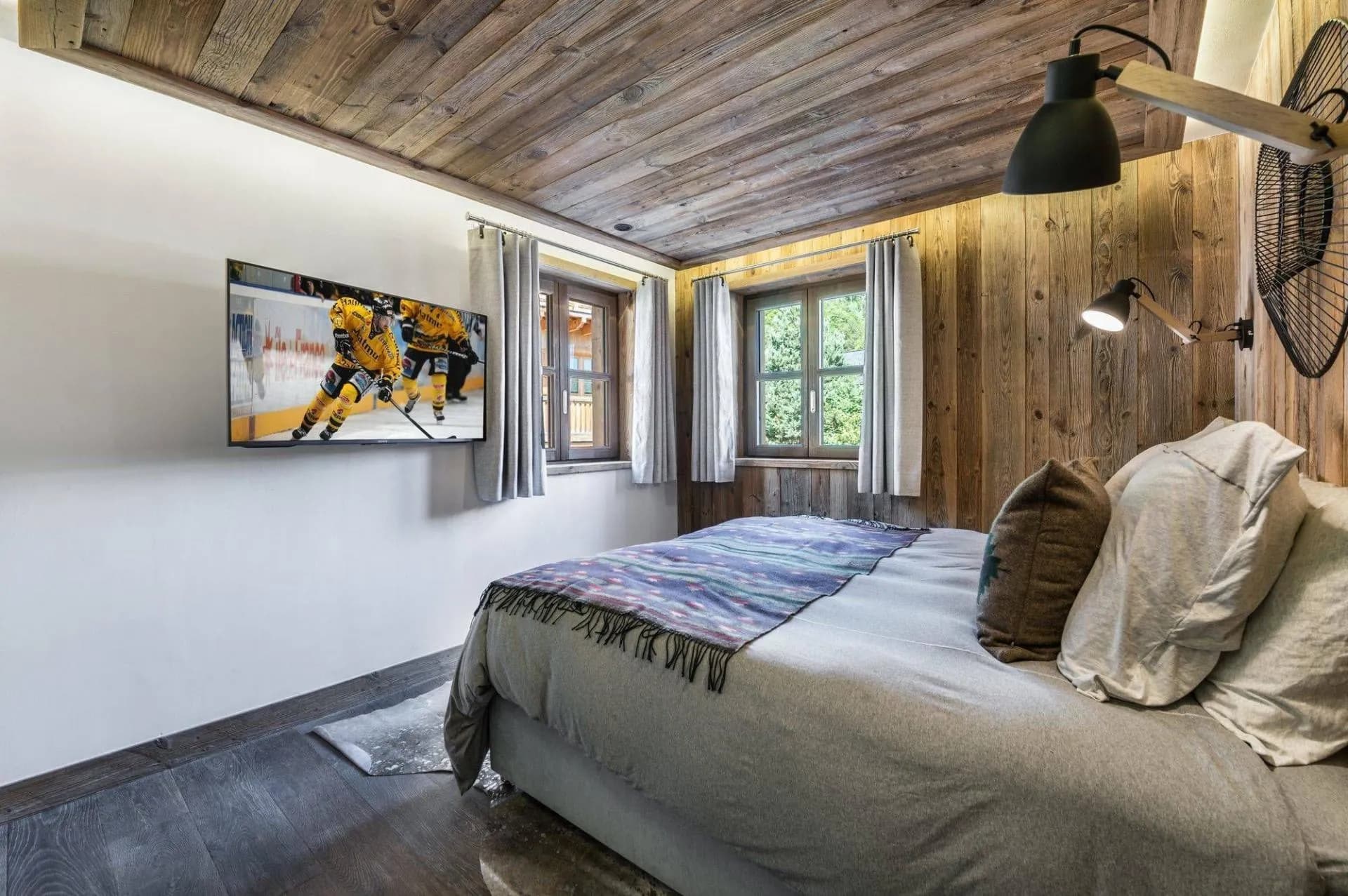 Double or twin bedroom with television and forest-facing windows