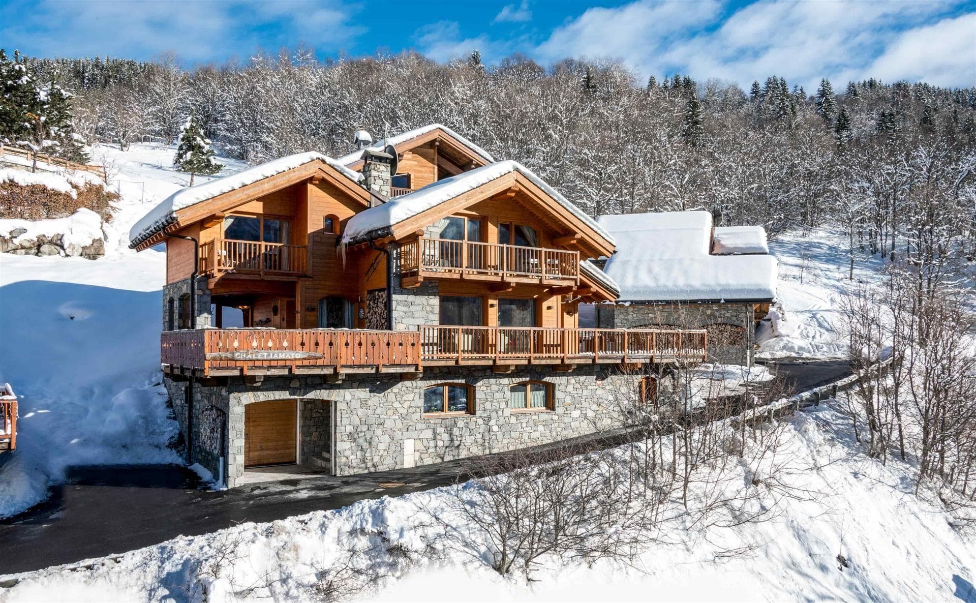 Ski-in chalet exterior with heated garage and wraparound timber balconies