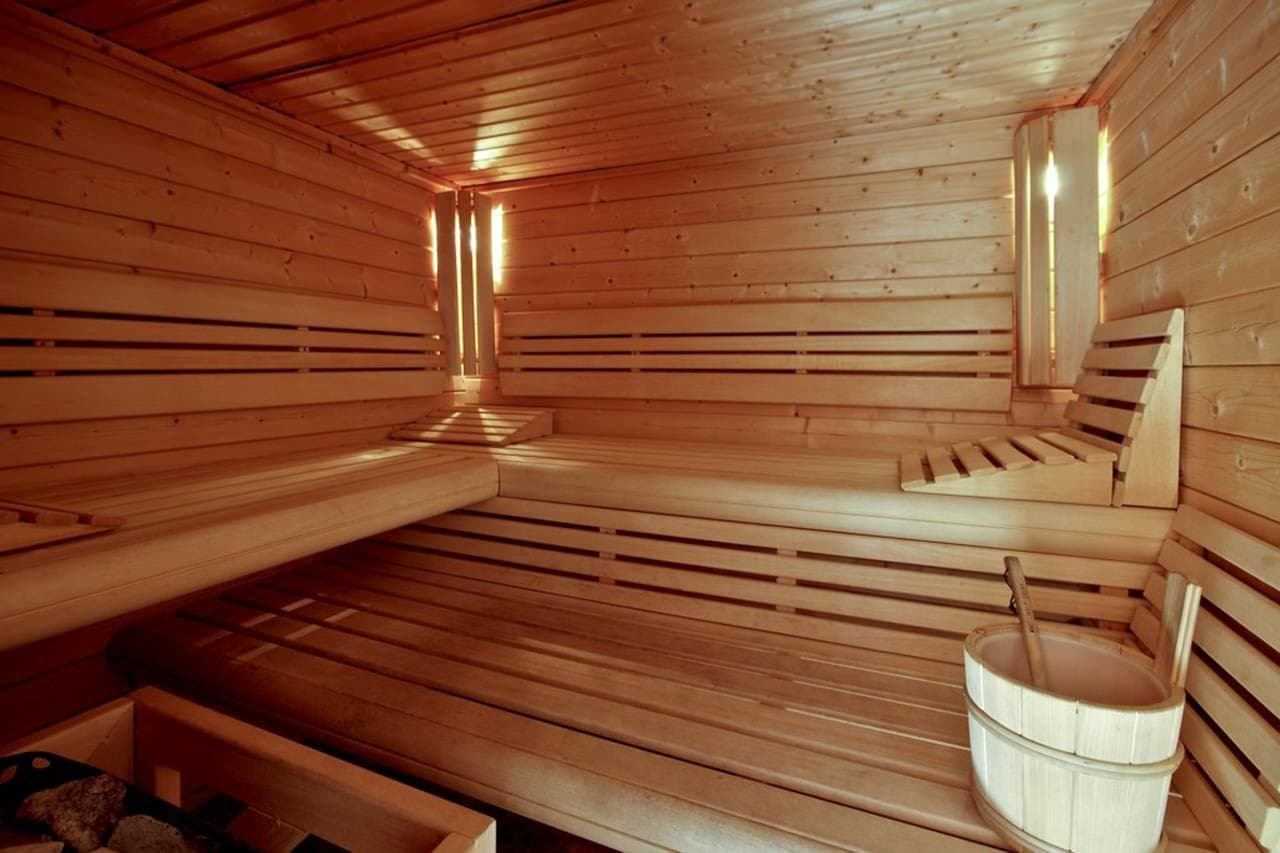 Cedar sauna with two-tier bench seating and integrated wooden backrests