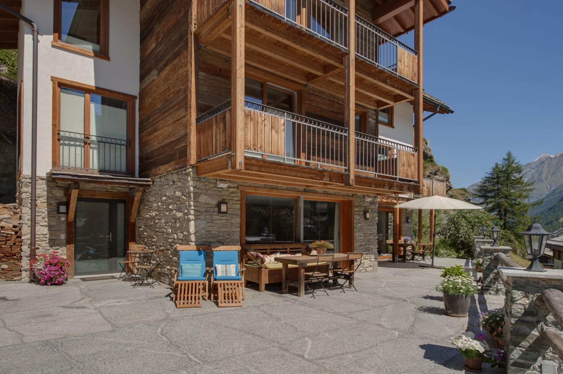 Stone patio with dining table and loungers; mountain views