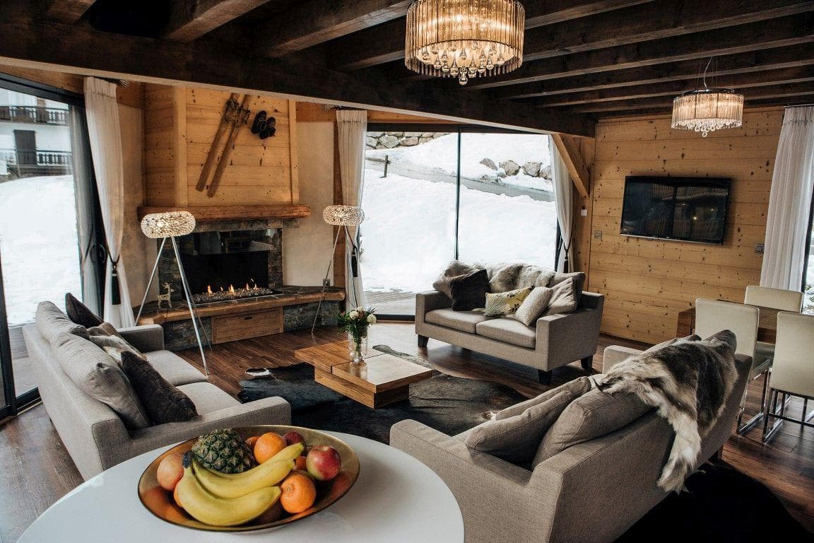 Living area with gas fireplace and floor-to-ceiling snow views