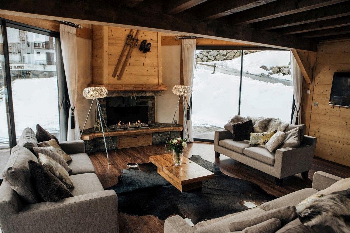 Living area with gas fireplace and floor-to-ceiling windows facing ski slopes