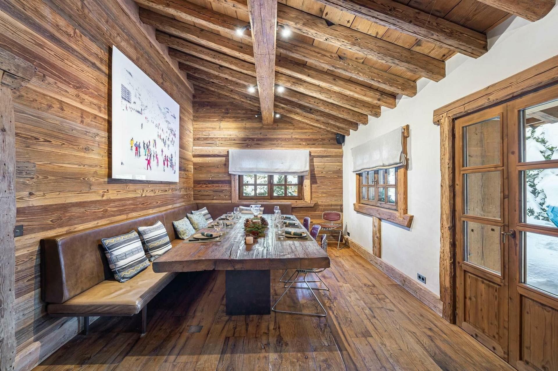 Dining area with large wooden table and banquet seating for 10