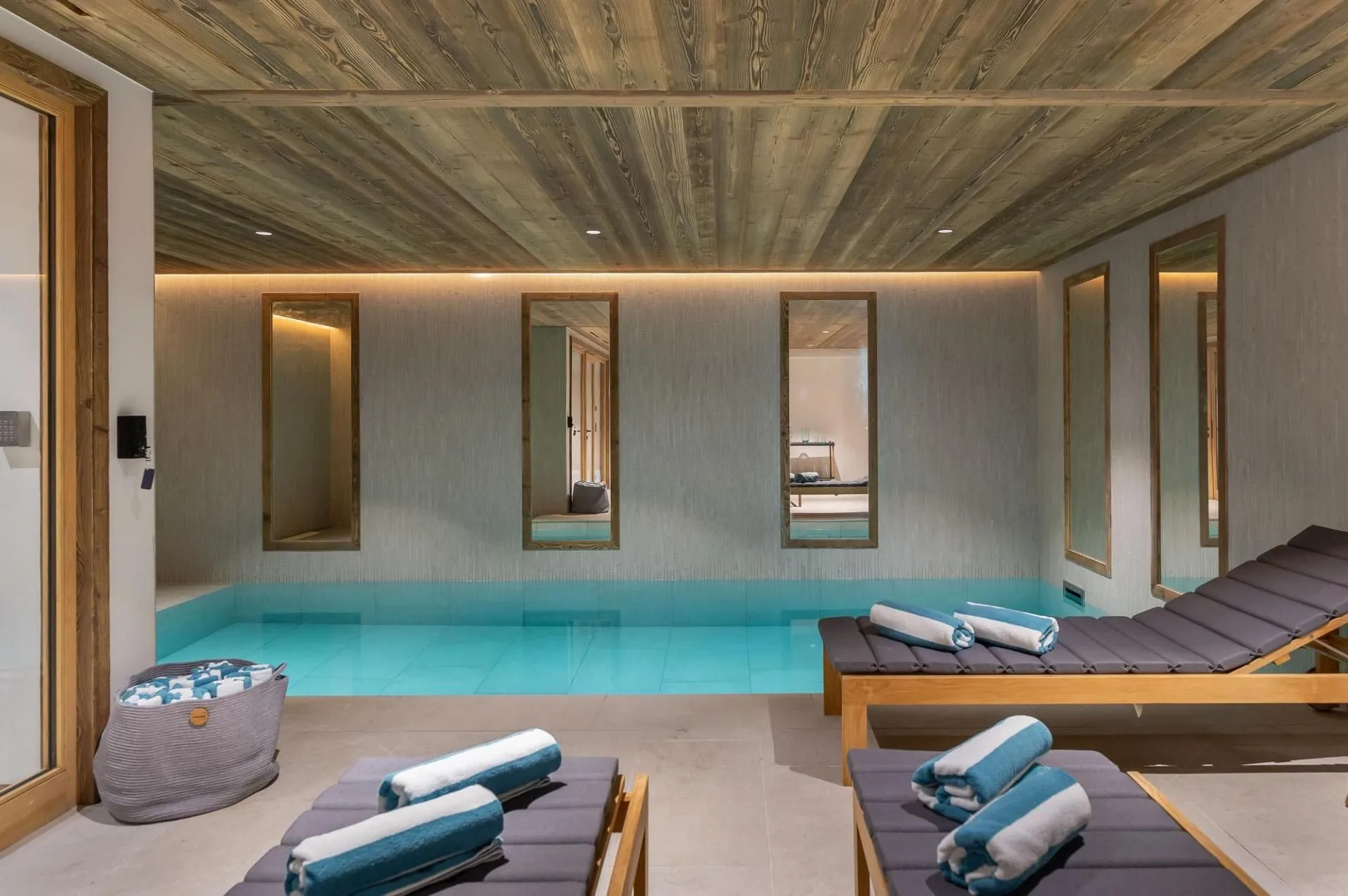 Indoor swimming pool with poolside lounge seating