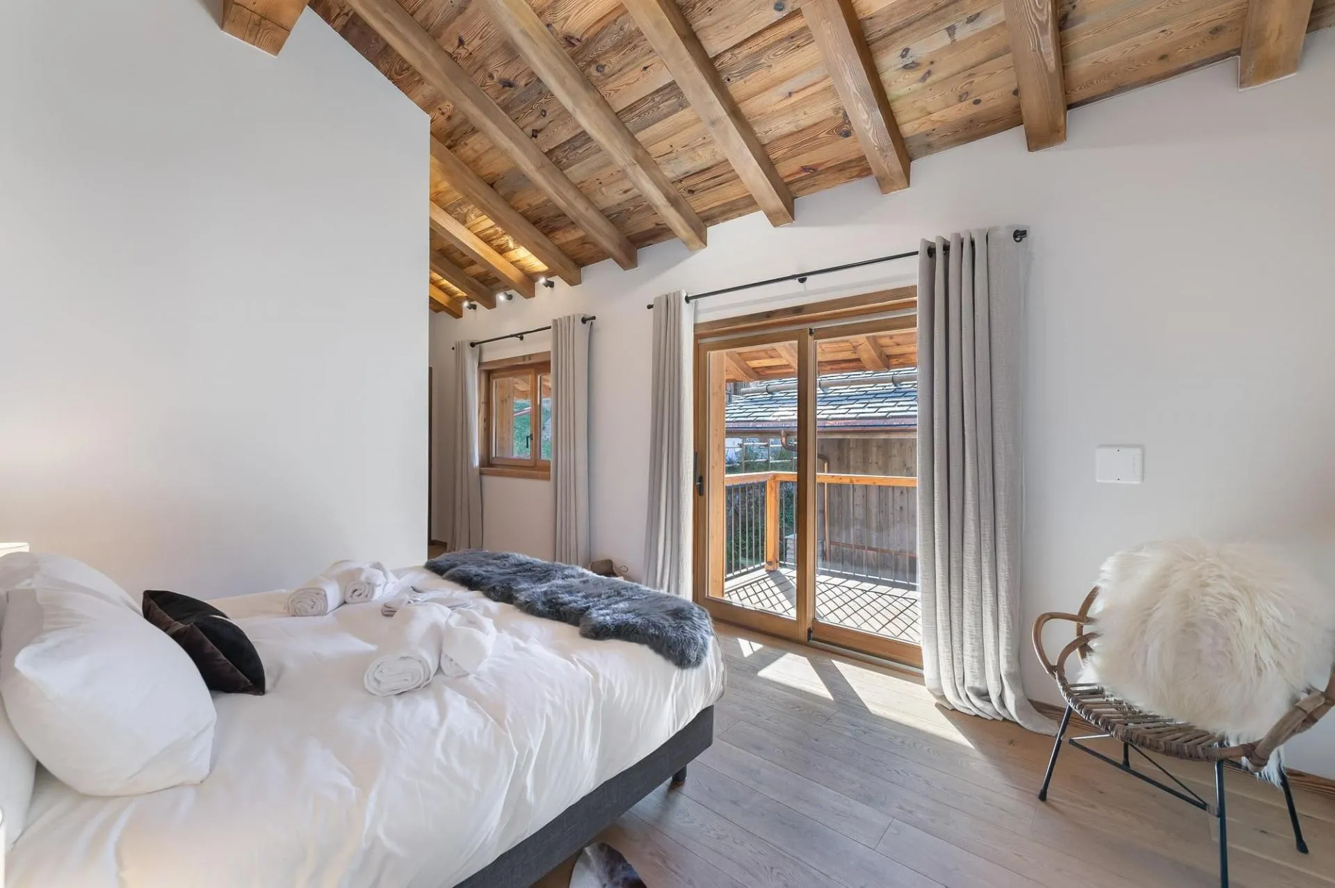 Double bedroom with a timber ceiling and balcony access