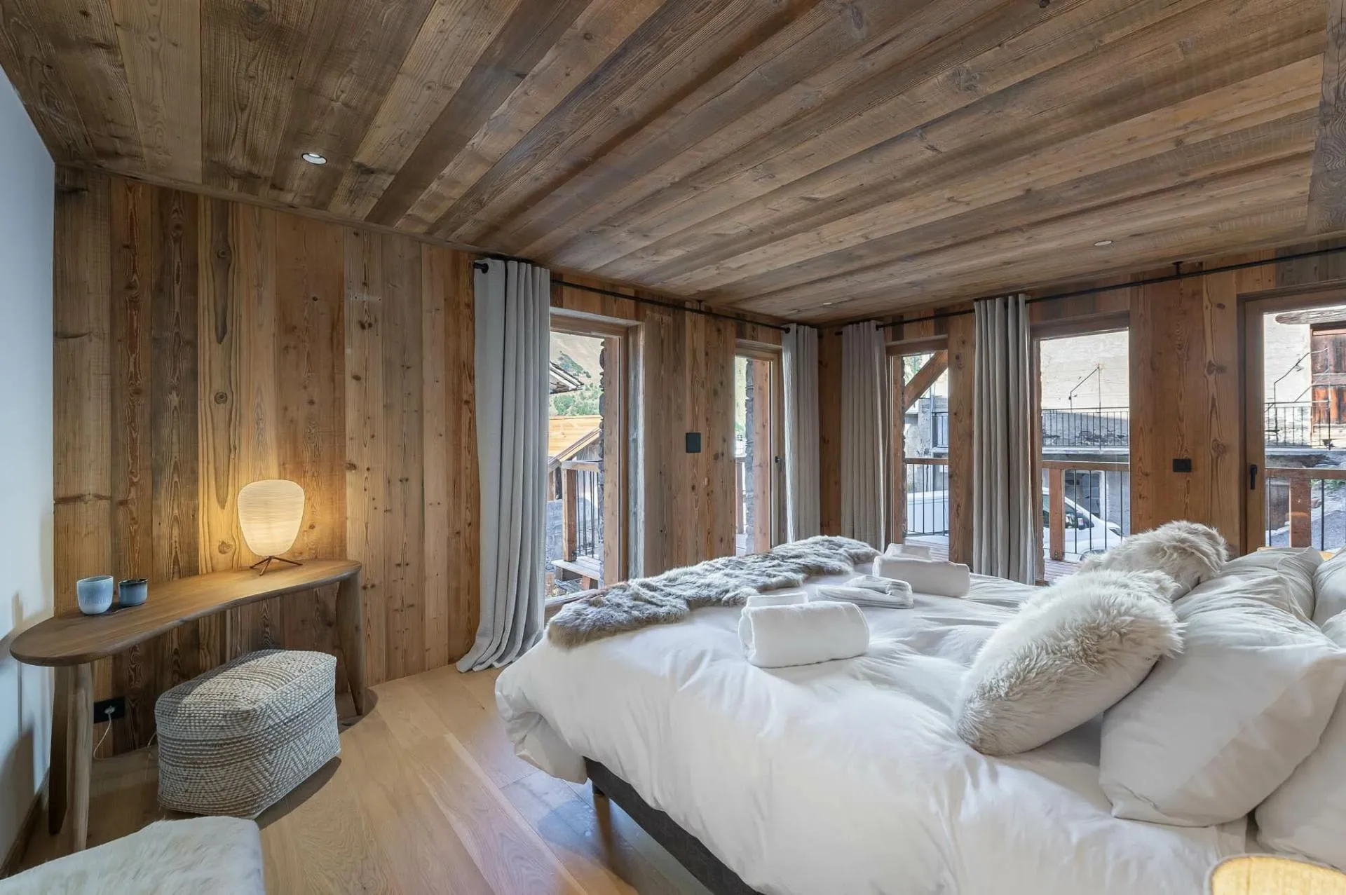 Double bedroom beneath a timber ceiling with balcony access