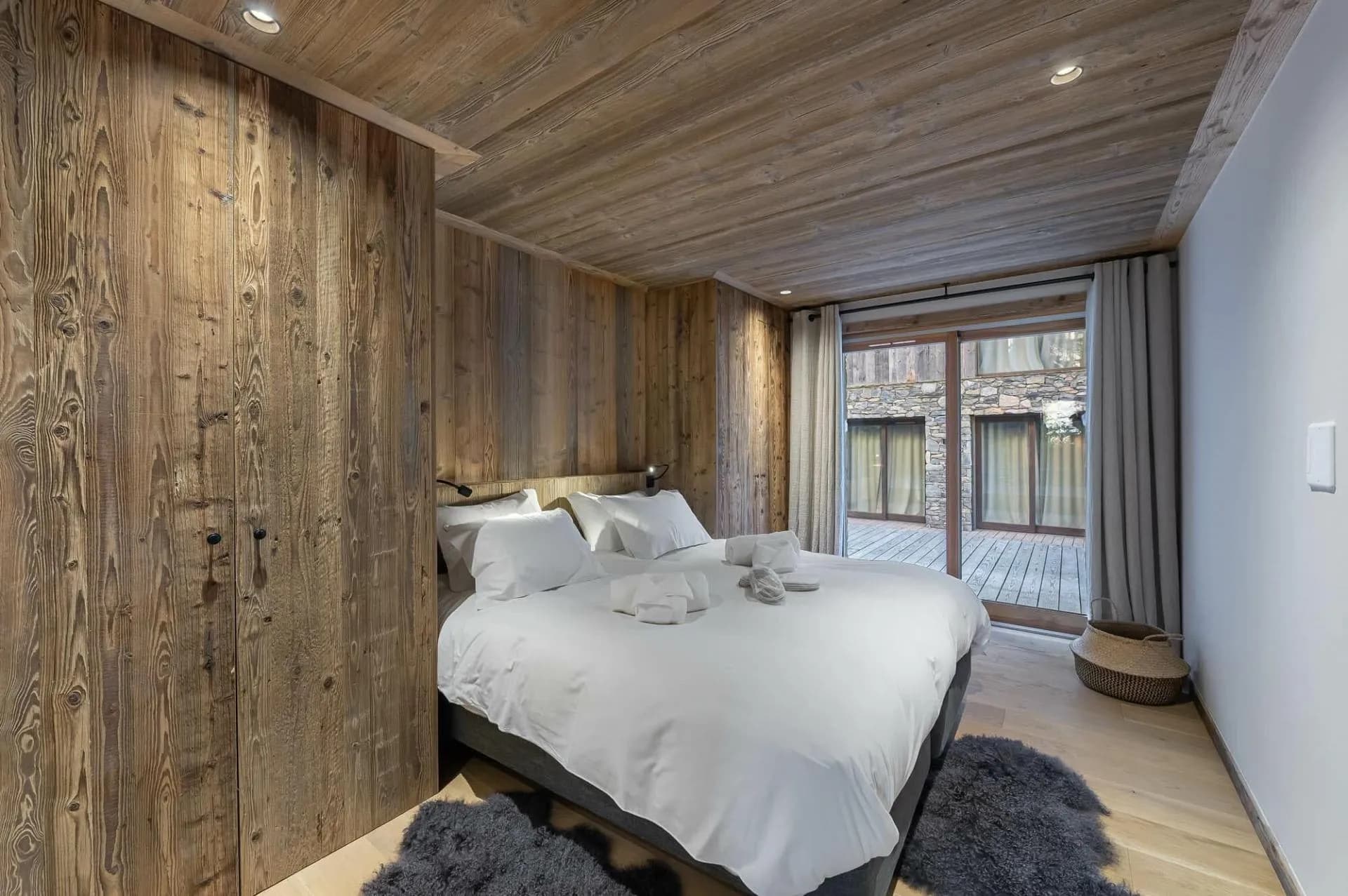 Double bedroom with timber panelling and terrace access