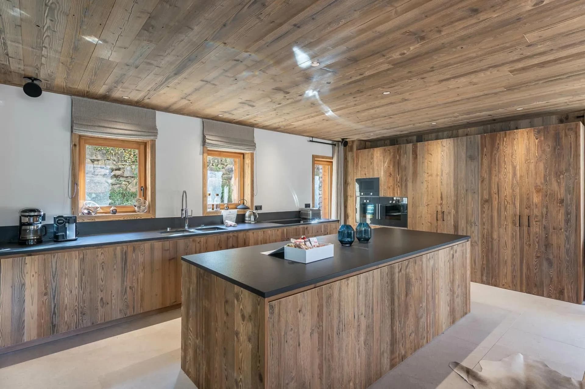 Kitchen with stone worktops, integrated appliances and timber cabinetry