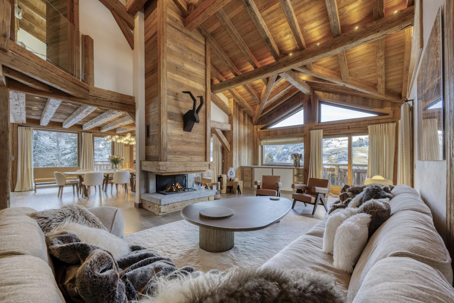 Open-plan living area with wood-burning fireplace and vaulted timber ceilings
