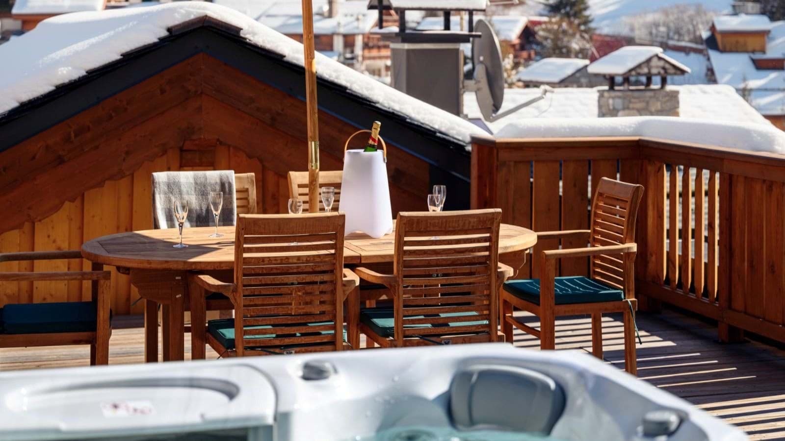 Outdoor terrace with hot tub and dining table seating six