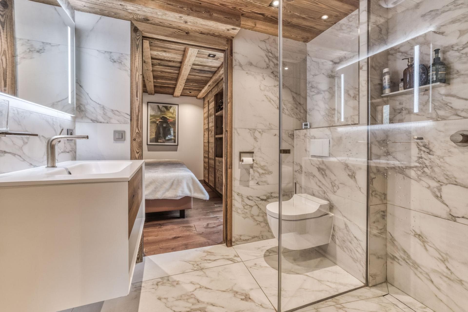 En suite bathroom with marble tile and walk-in glass shower