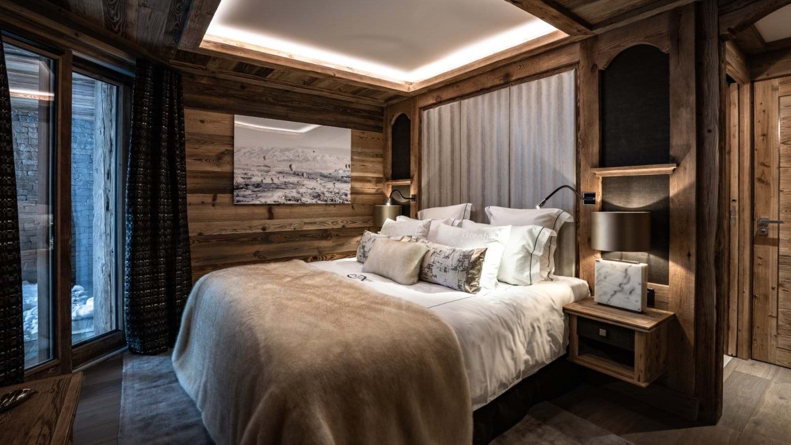 Wood-paneled bedroom with king bed and adjustable reading lights