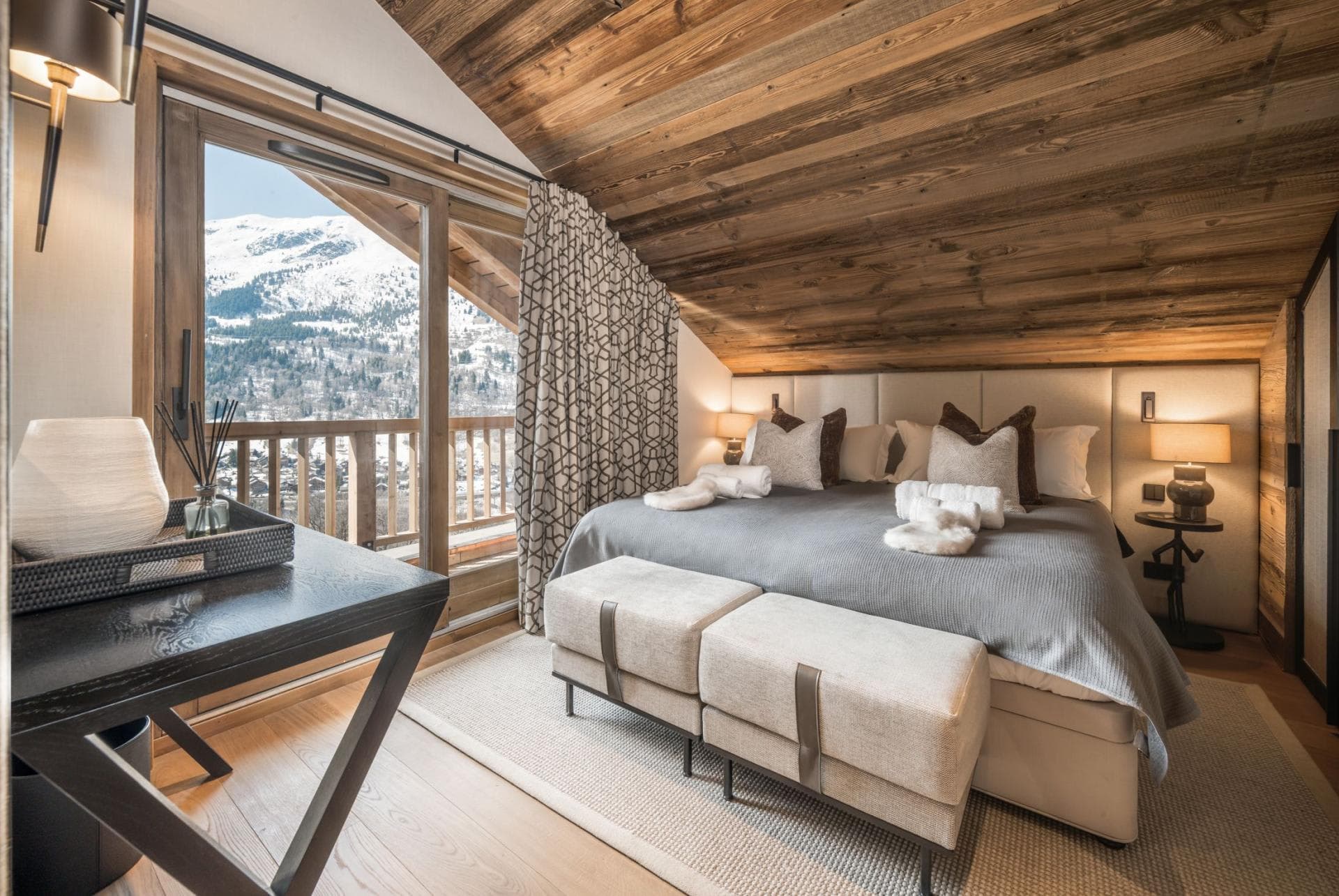 Top-floor bedroom with king bed and private balcony overlooking ski slopes