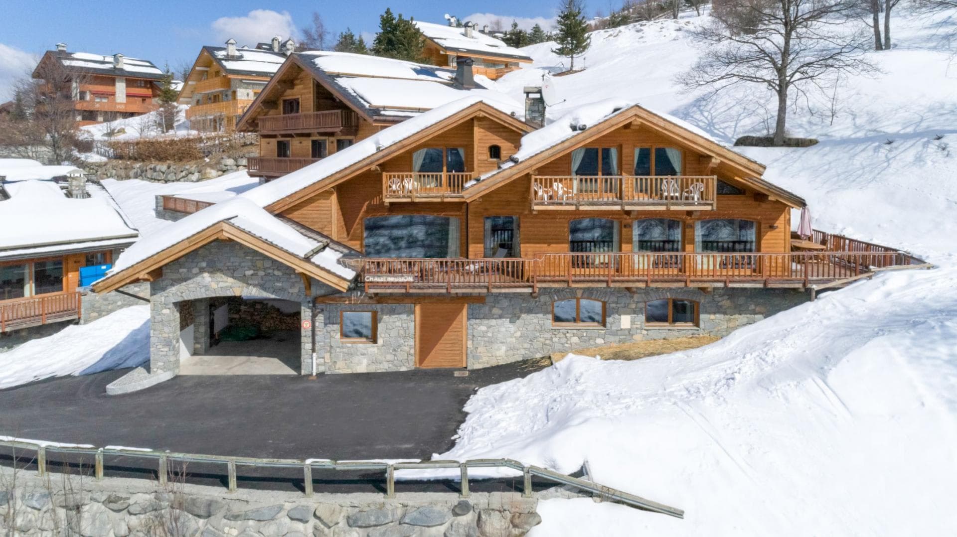 Ski-in/ski-out chalet exterior with stone-walled carport and wraparound balconies