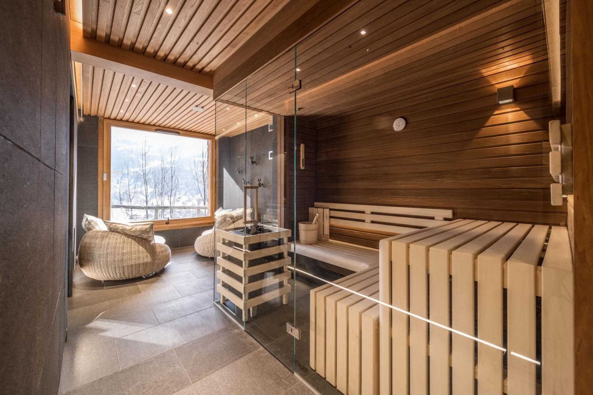 Private sauna with glass wall and adjacent lounge area overlooking valley