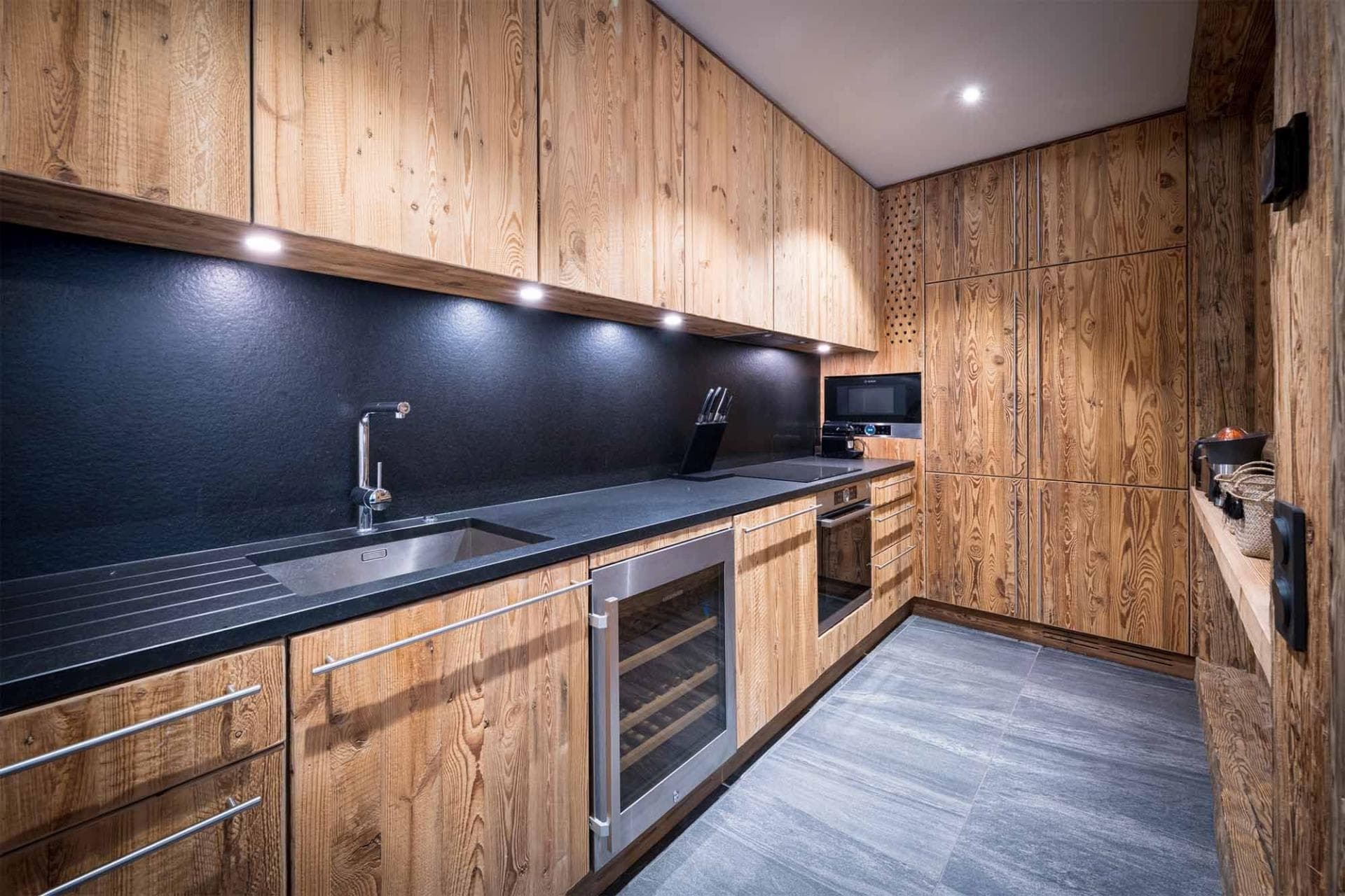 Kitchen with reclaimed wood cabinetry, wine fridge, and built-in Bosch oven