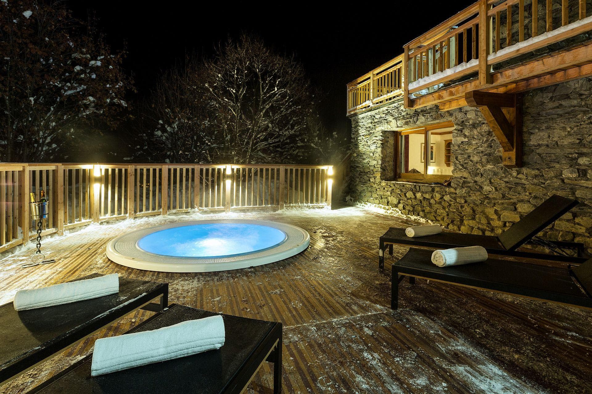 Sunken outdoor hot tub on timber deck with lounge seating