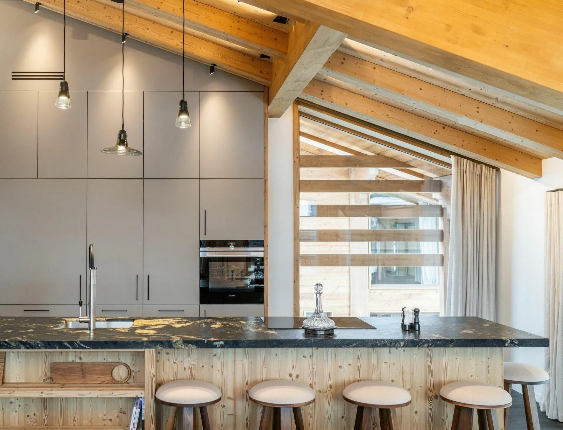 Kitchen island with stone worktop and bar seating