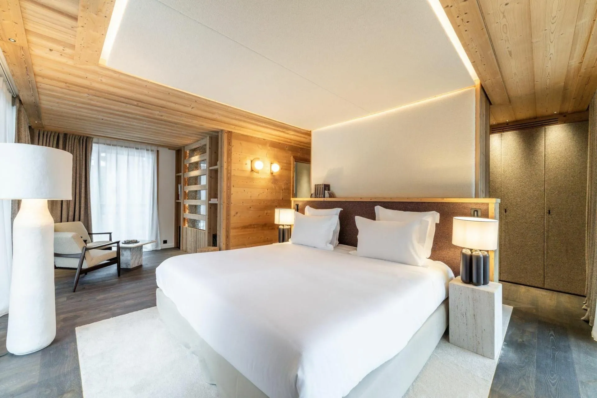 Double bedroom with an armchair and timber feature wall