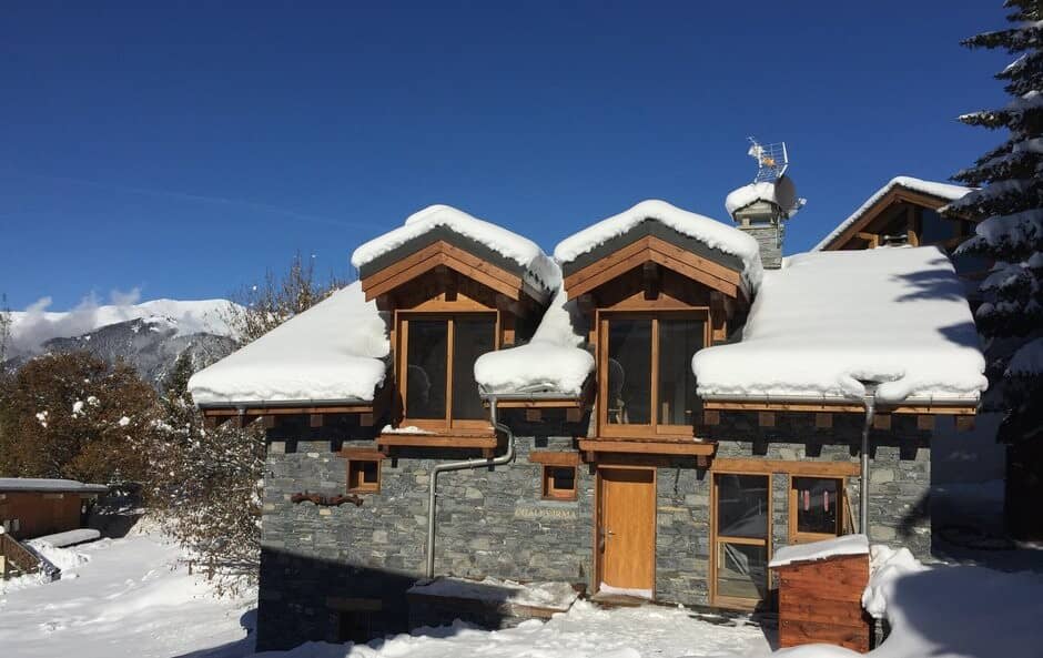 Stone and timber chalet exterior with mountain views and dormer windows
