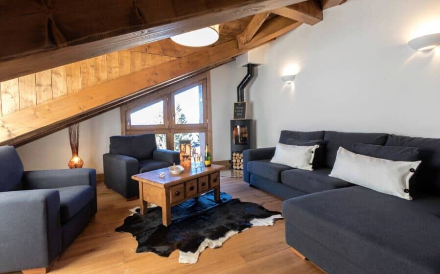 Loft living area with wood-burning stove and vaulted timber ceilings