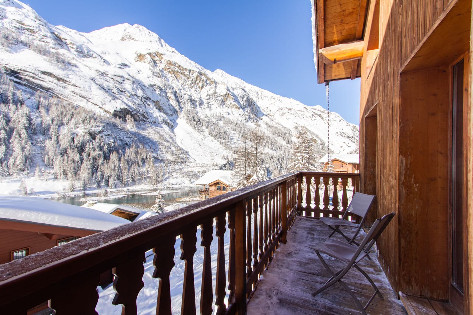 Balcony with mountain and frozen lake views; two chairs provided