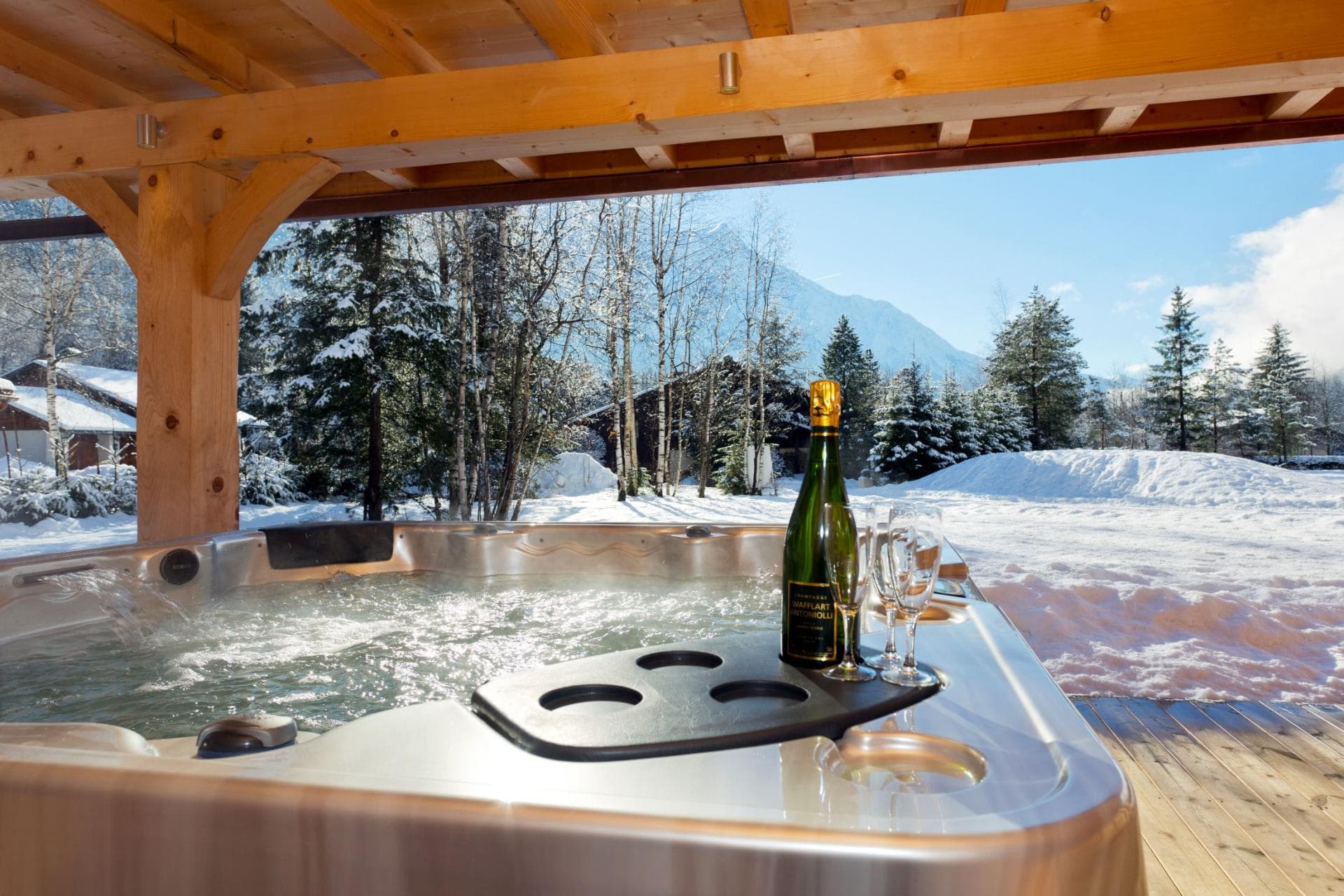 Covered outdoor hot tub with mountain views and built-in drink tray