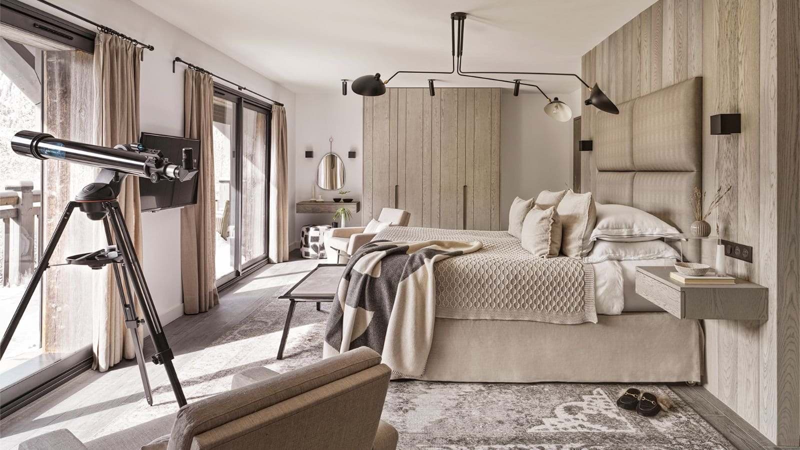 Primary bedroom with king bed, telescope, and balcony access