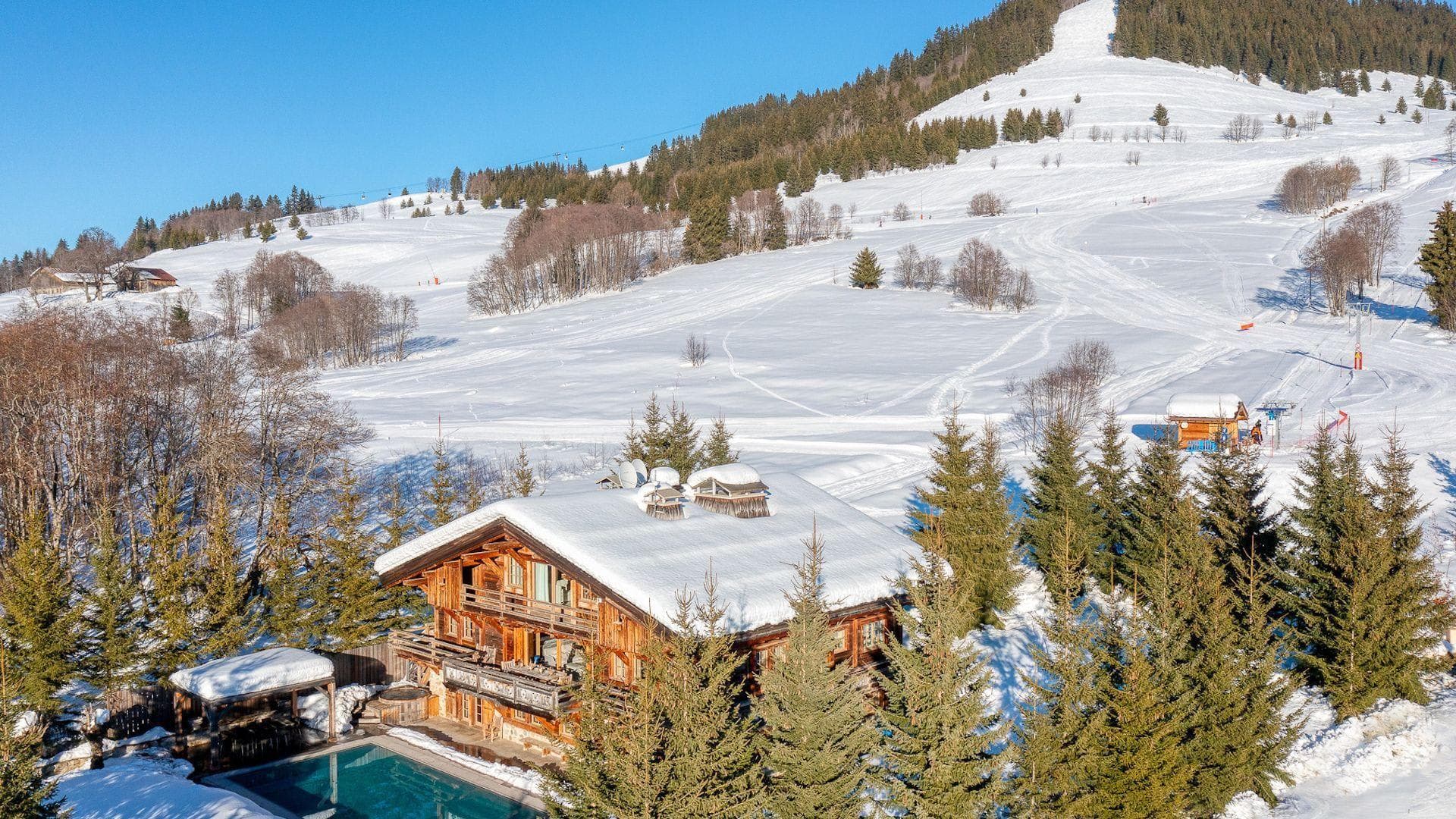 Alpine lodge with heated pool overlooking ski runs and valley