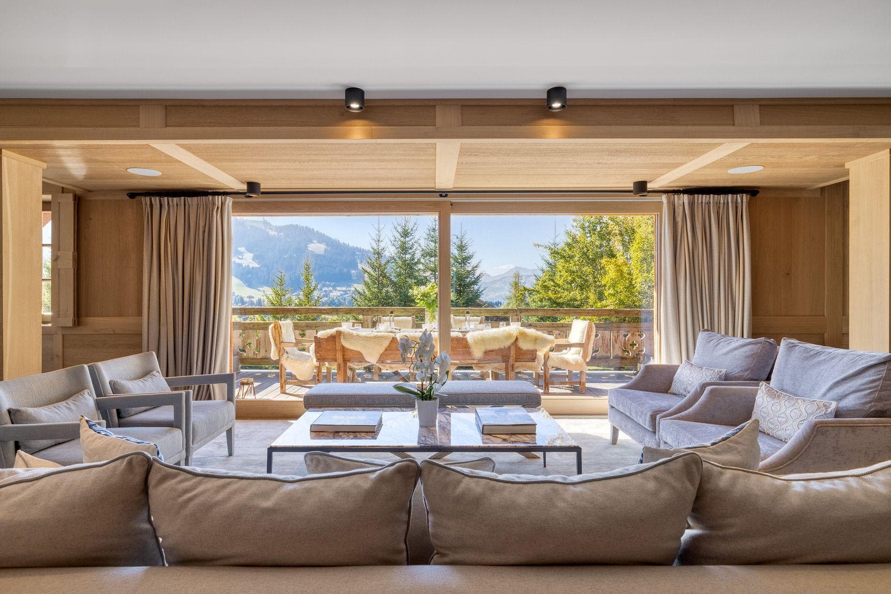 Living room with sectional seating for 10; floor-to-ceiling windows frame mountain and valley views