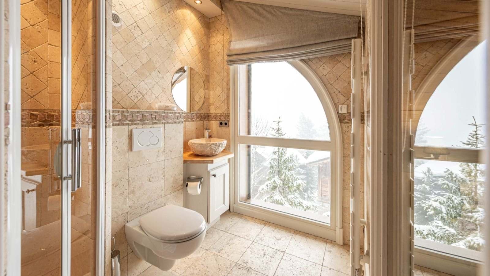 Bathroom with walk-in shower and heated towel rail; snowy forest views