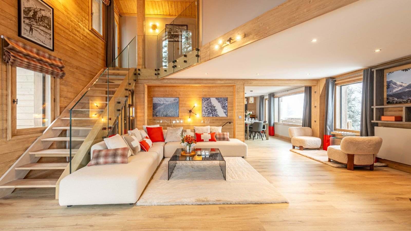 Open-plan living area with sectional seating and glass-walled staircase