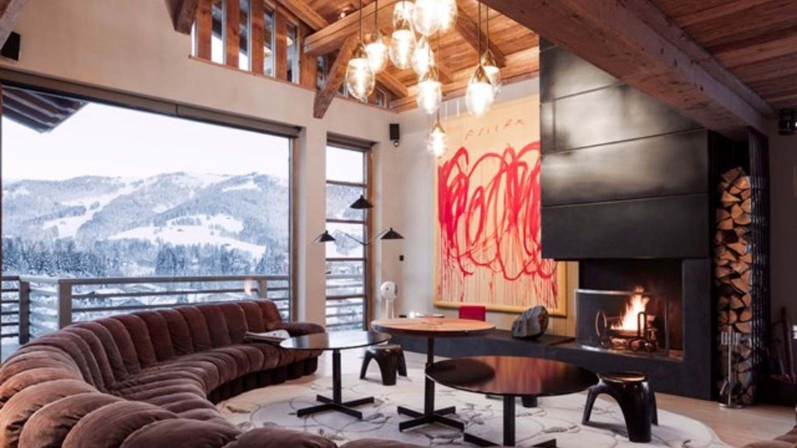 Living area with wood-burning fireplace and floor-to-ceiling mountain views