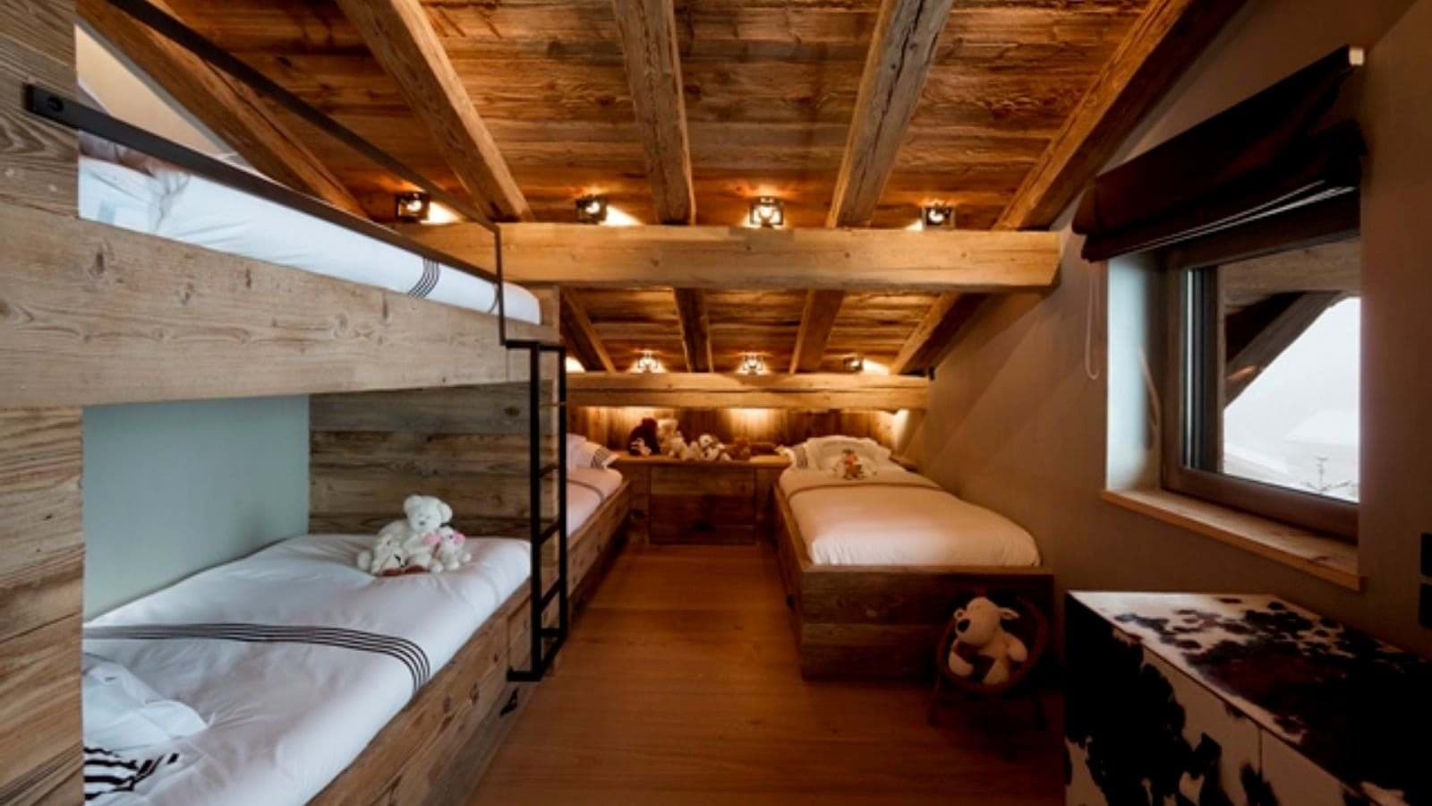 Bunk room with four twin beds and reclaimed timber ceilings