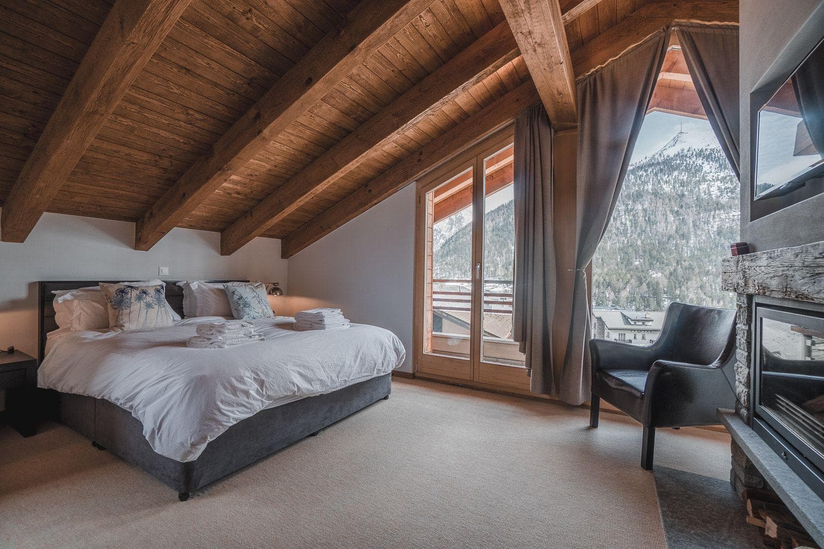 Top-floor bedroom with king bed, fireplace, and private balcony