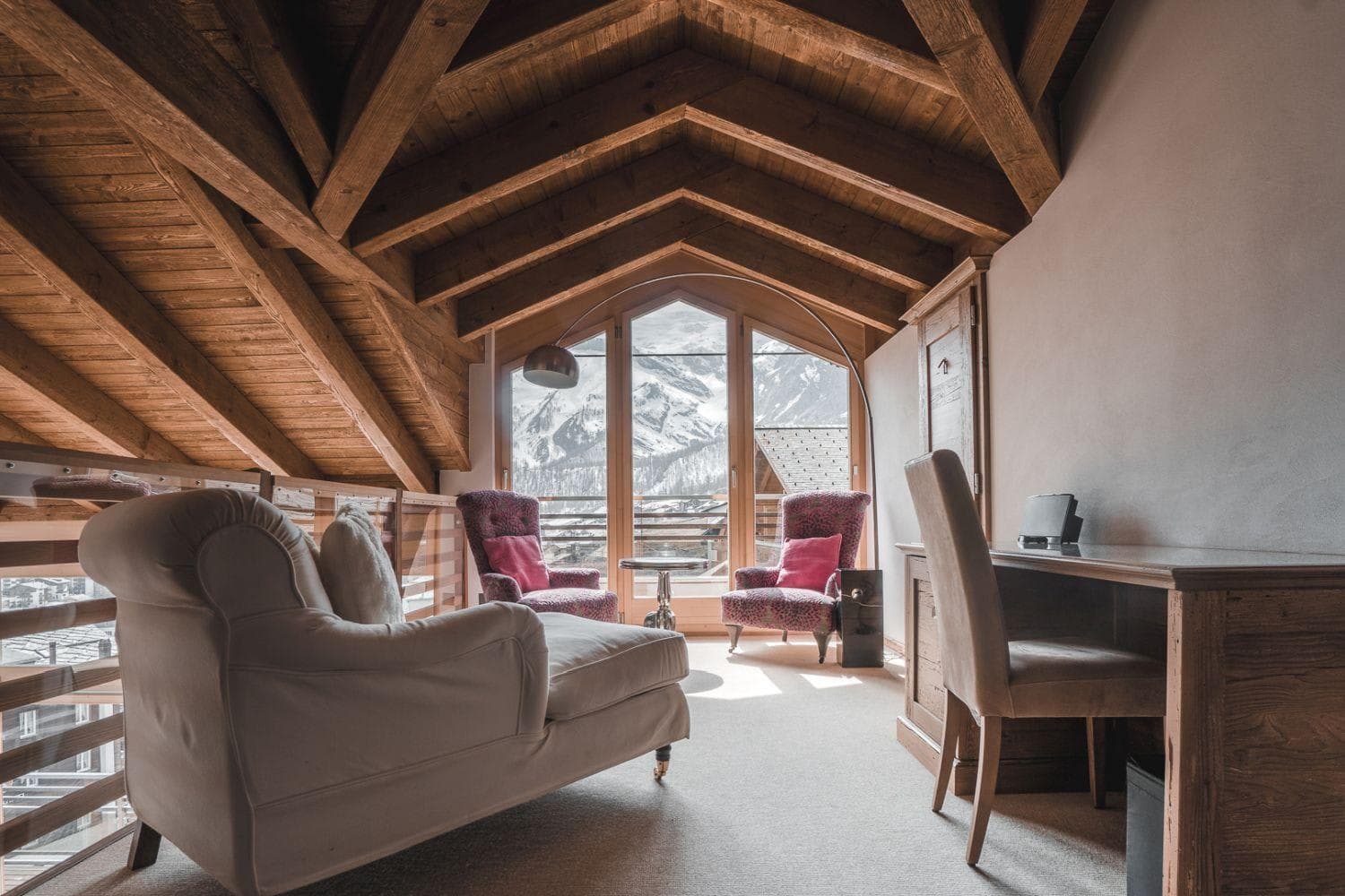 Loft lounge and workspace with vaulted timber ceilings and mountain views