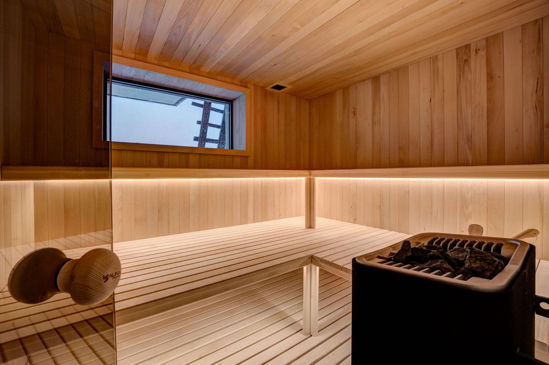 Cedar sauna with multi-level bench seating and integrated window