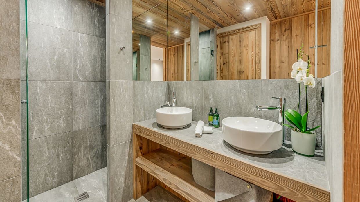 Bathroom with dual vessel sinks and walk-in stone rainfall shower