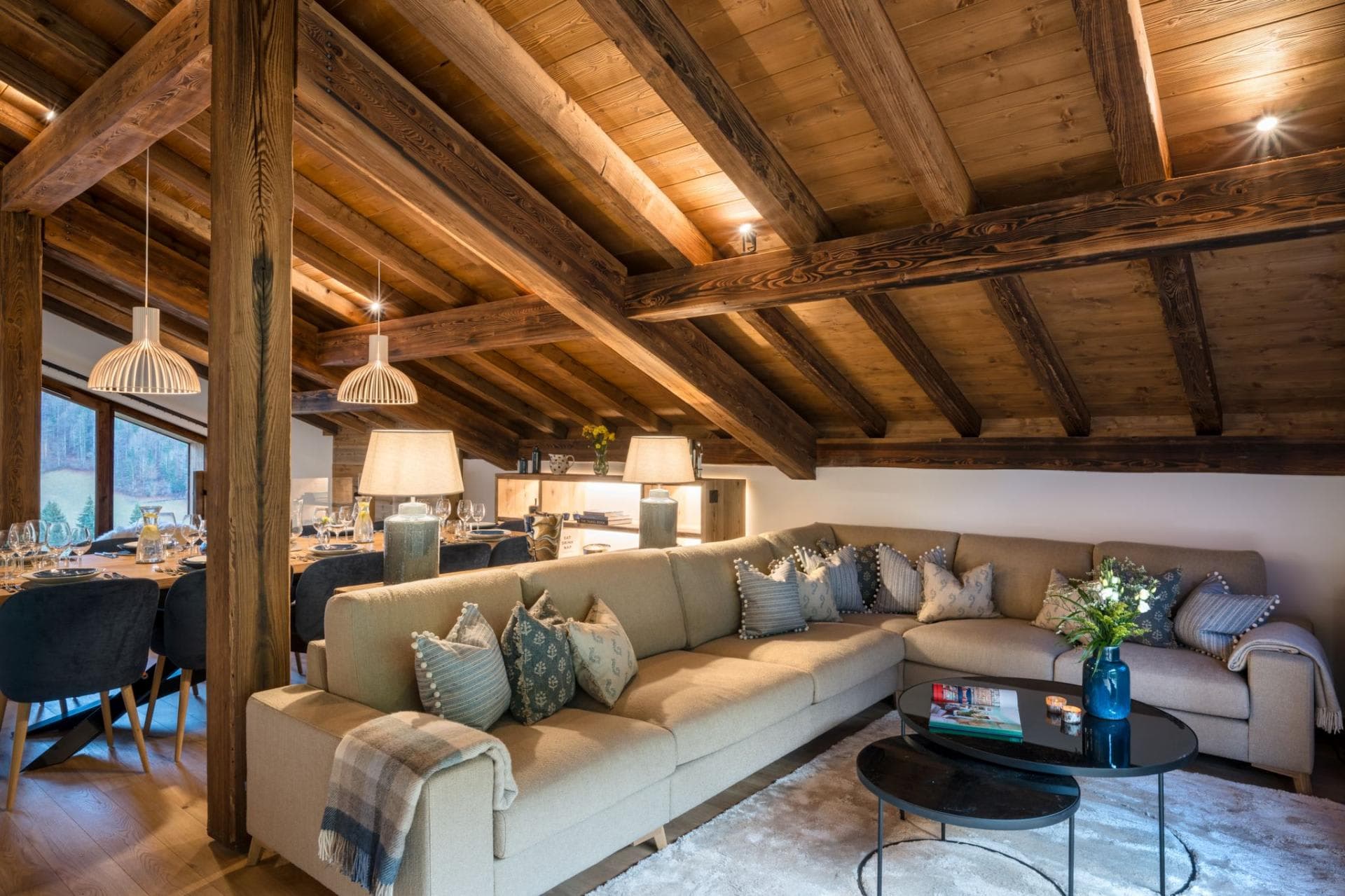 Open-plan living area with vaulted timber ceilings and sectional seating