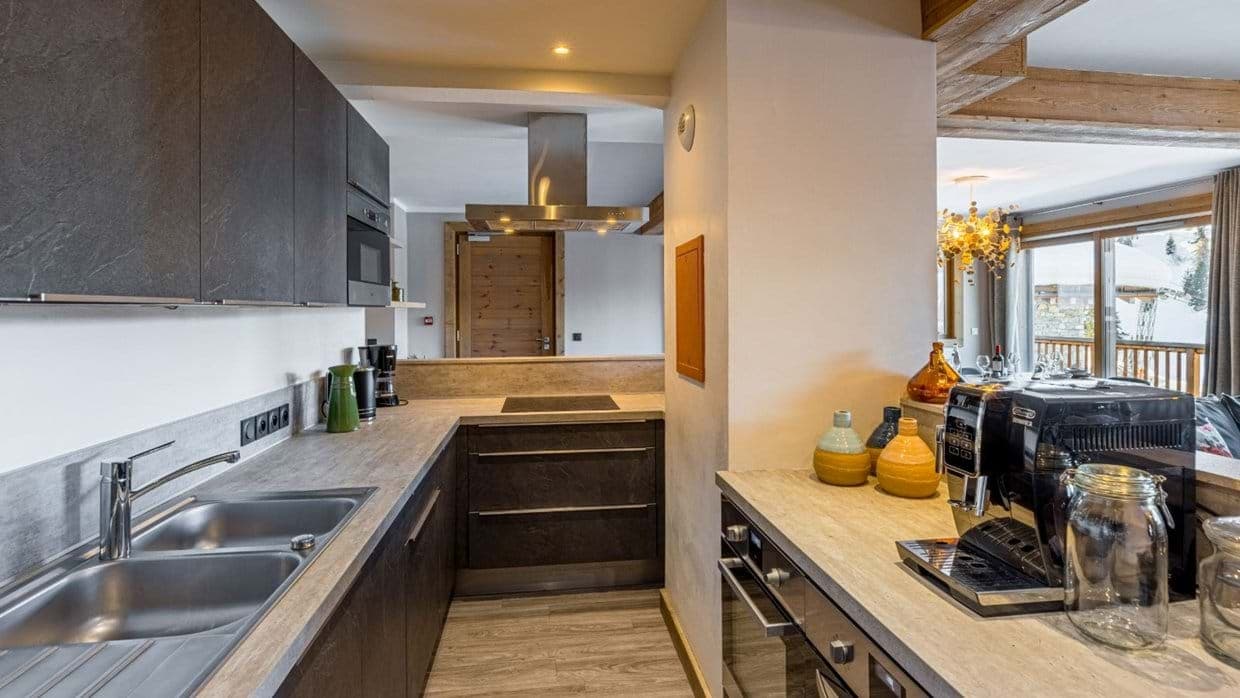 Kitchen with dual sink and espresso machine; mountain views through dining area